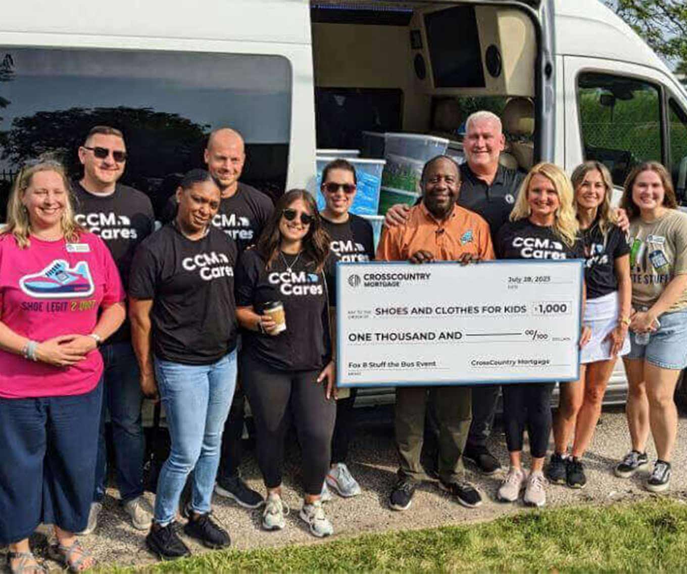 CCM volunteers surprising the FOX 8’s annual Stuff the Bus organization with an additional $1,000 donation