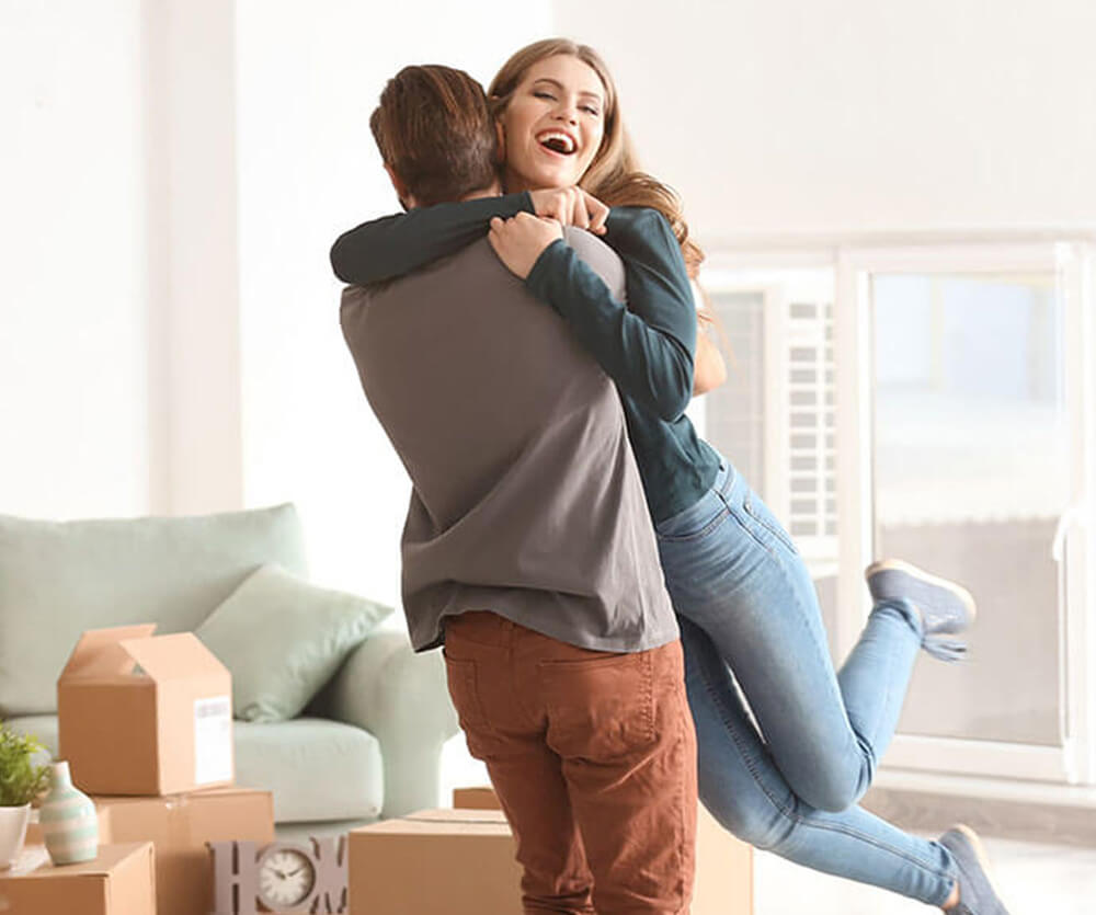 Couple hugs after moving into new home using CCM CashPlus mortgage loan product.