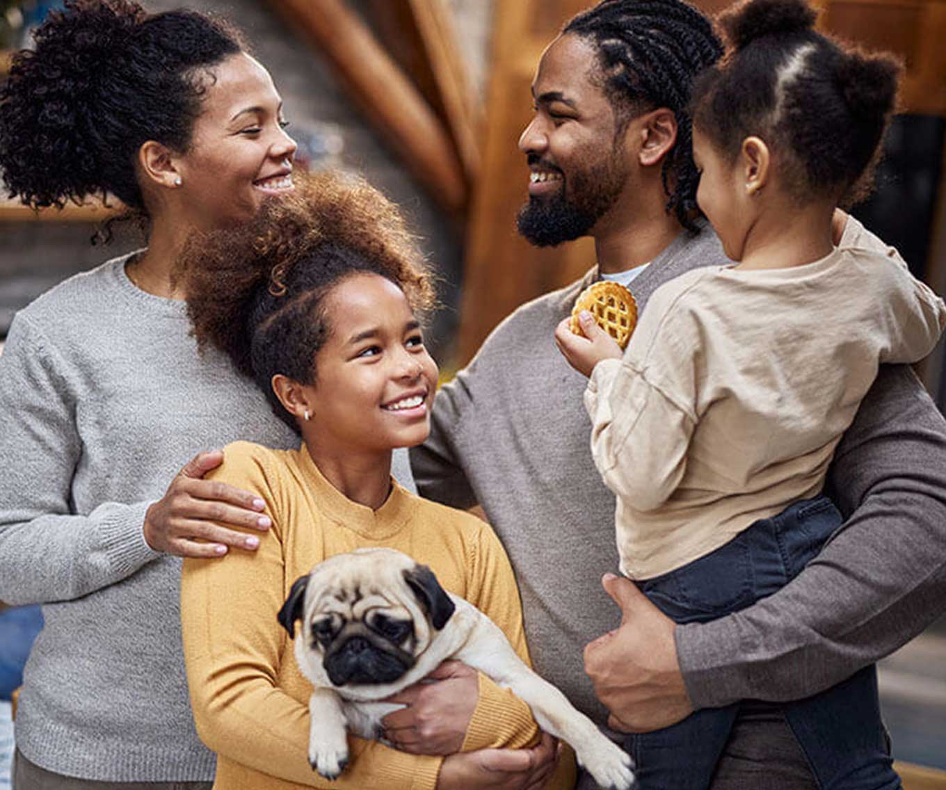 Parents and their two children pose together with their dog.