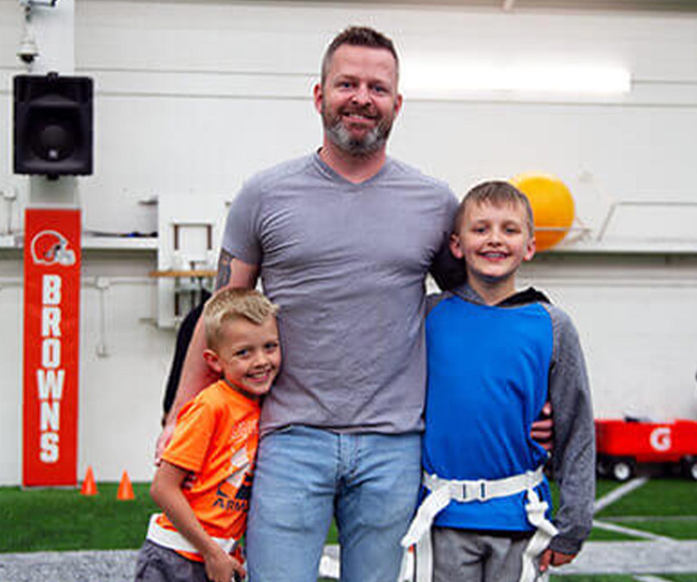 A military dad and his two sons standing together.