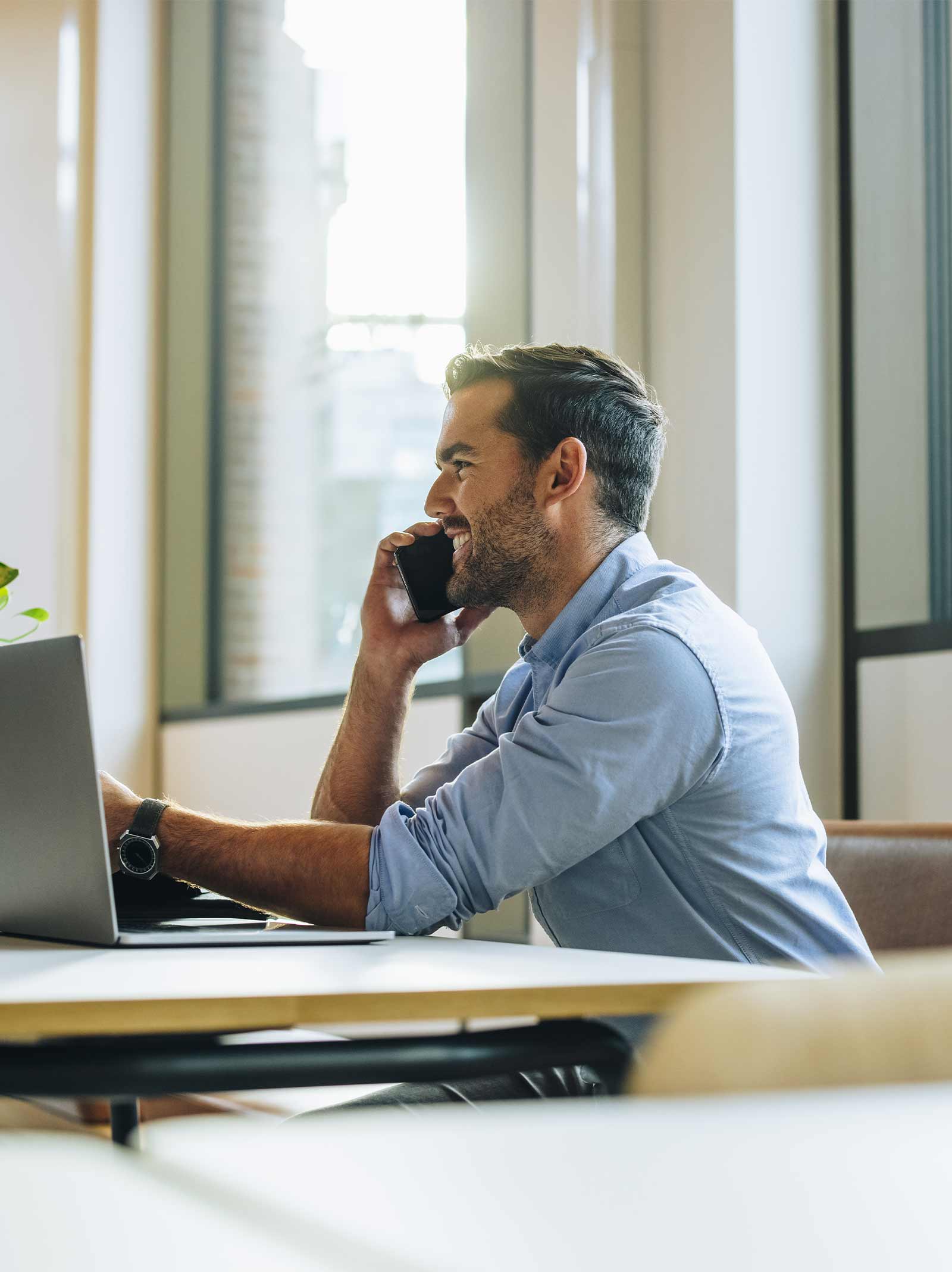 Man on cell phone at coffee shop learns about the down payment assistance programs available.