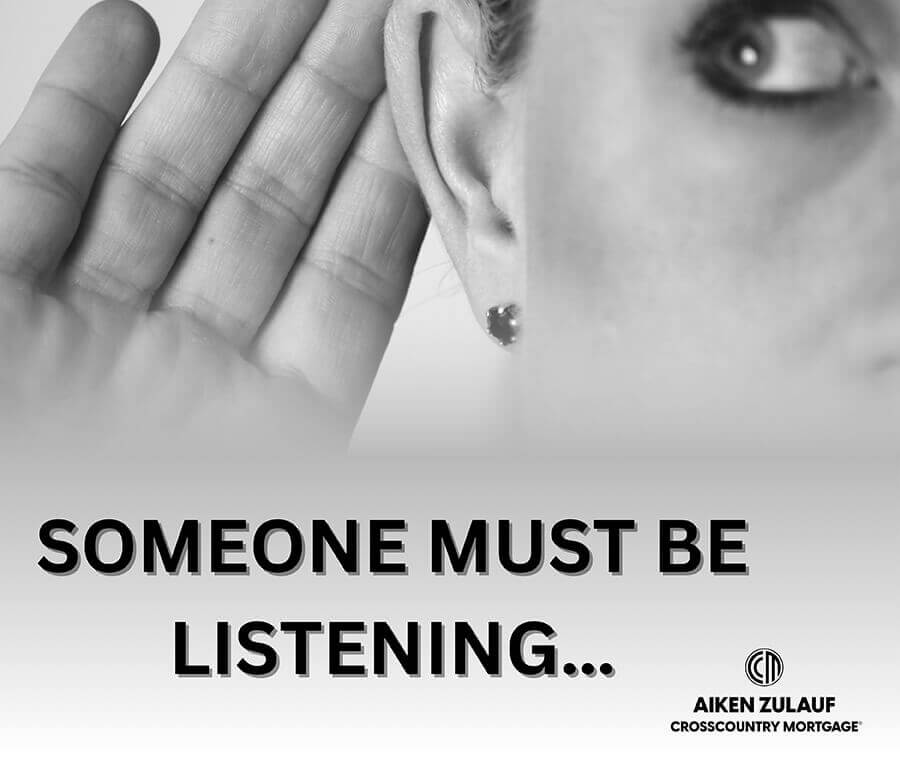 A woman holding her hand up to her ear.