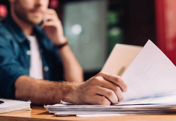 selective focus of a man holding documents on desk