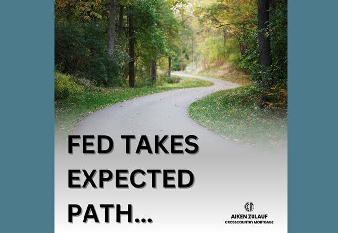 A paved winding path through the woods. The bottom left of the image contains the text "Fed takes expected path"