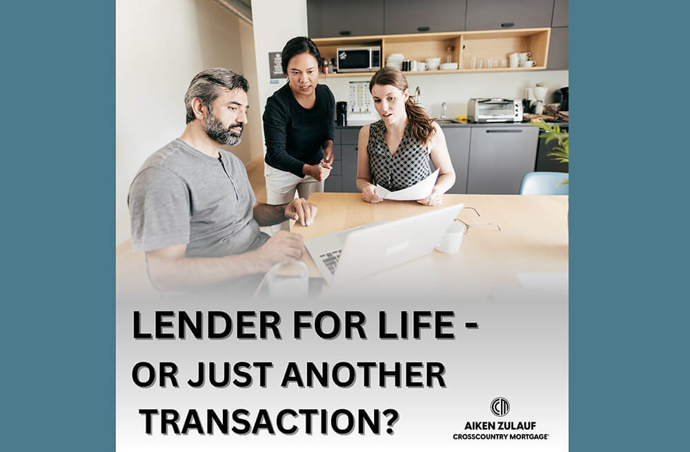 A mortgage professional talking to a couple at a kitchen table, looking at a laptop and paperwork.