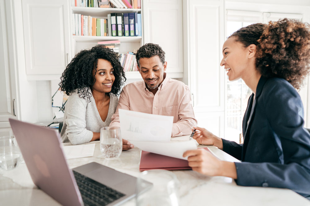 A couple meeting with a loan officer. They are reviewing their mortgage.