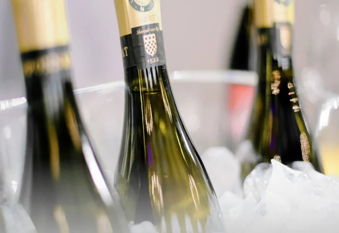 Three champagne bottles on ice.