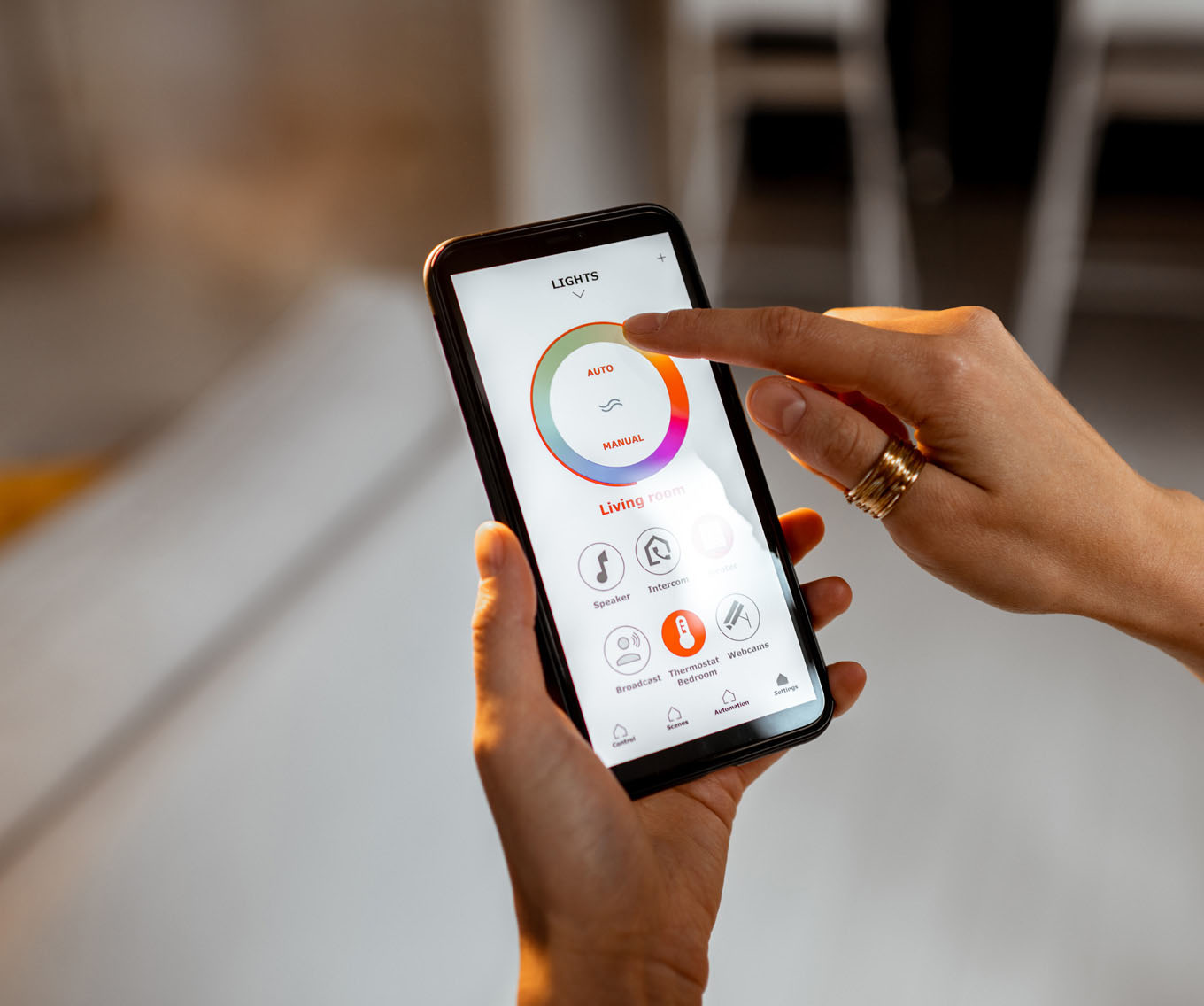 Homeowner looks at mobile app for smart home technology on their mobile device.