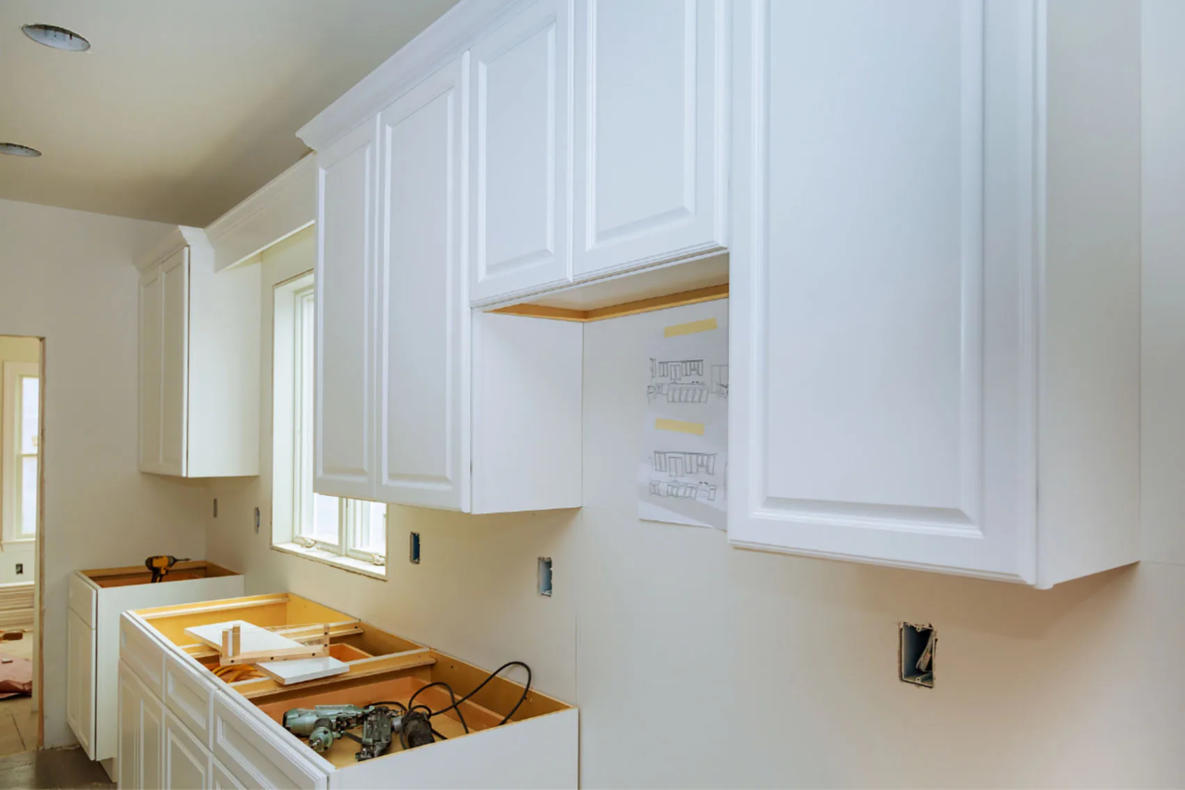 A home kitchen getting cabinets installed during a renovation.