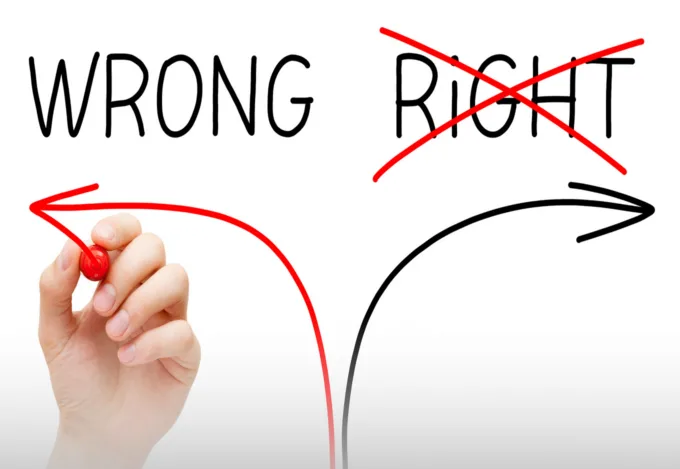 A hand drawing arrows turning to the left and right on a board. One labelled "Wrong", the other labelled "Right". "Right" is crossed out.