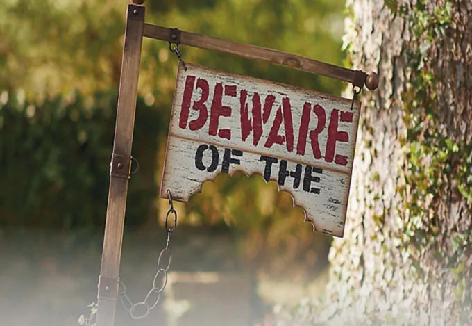 A yard sign reading "Beware of the" with a bite taken out of the bottom.