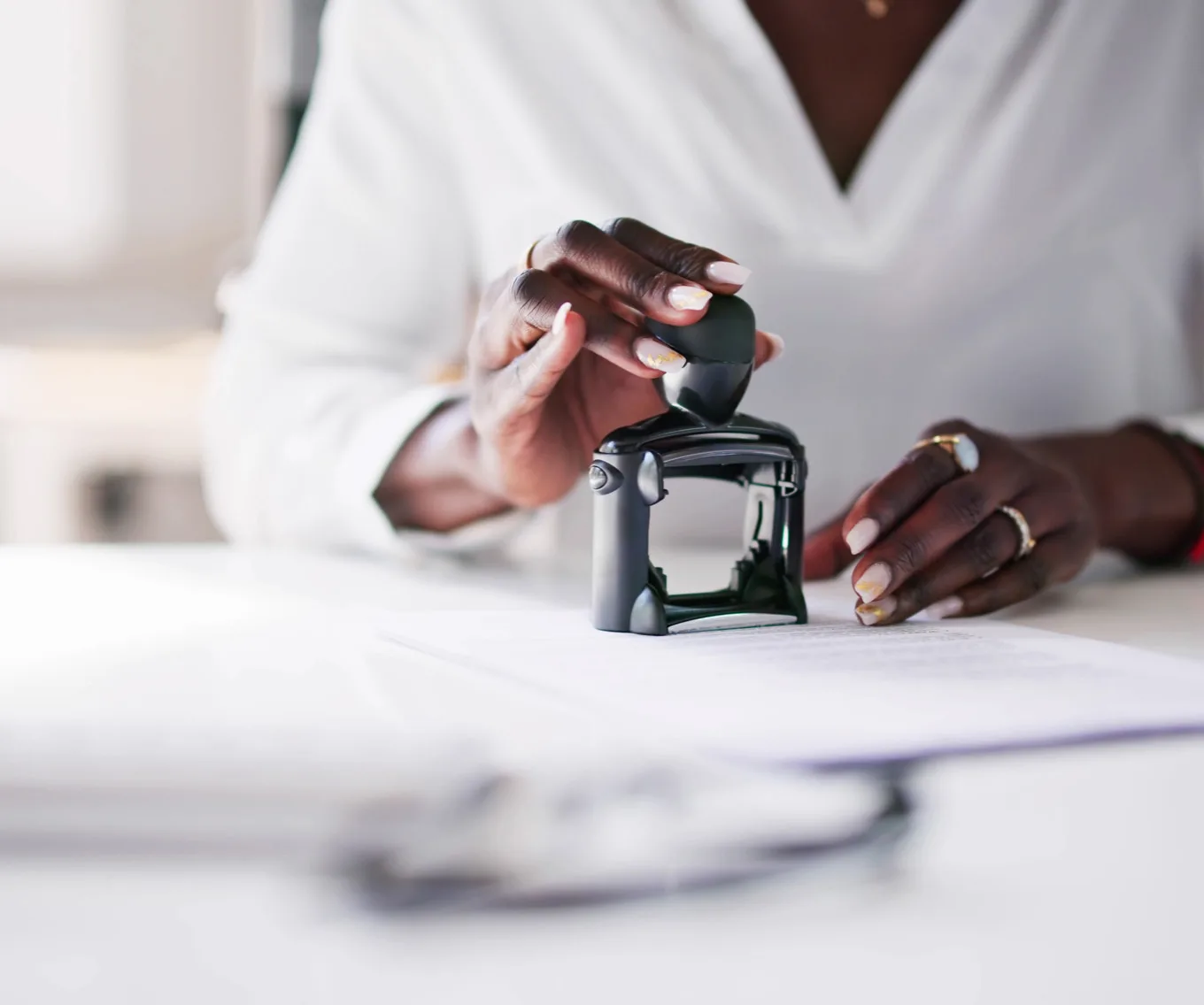Notary signing agent stamping a document during a mortgage loan closing appointment.