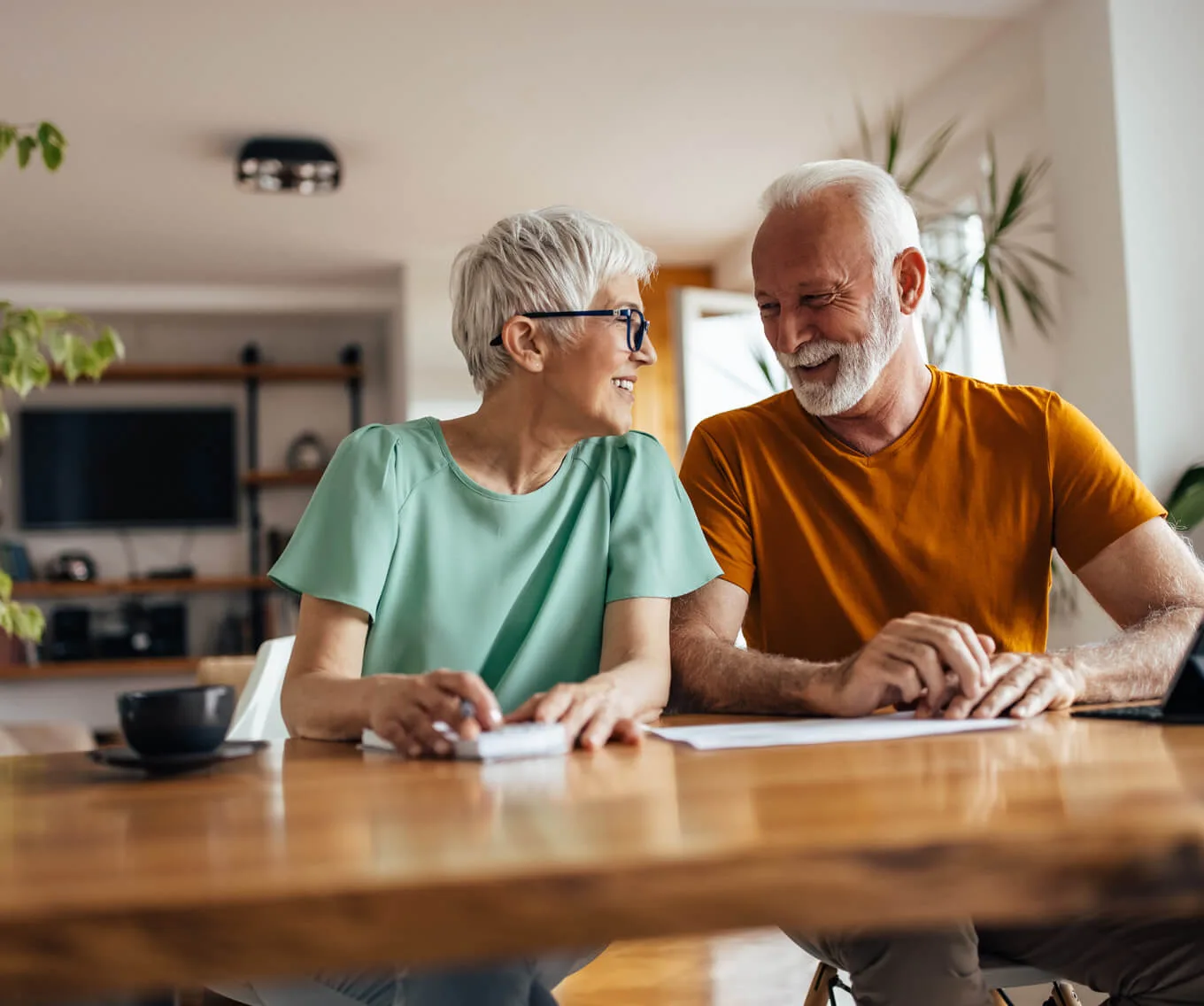 Senior homeowners smiling and reviewing paperwork together, illustrating 2026 housing trends and the rise of equity-rich buyers.