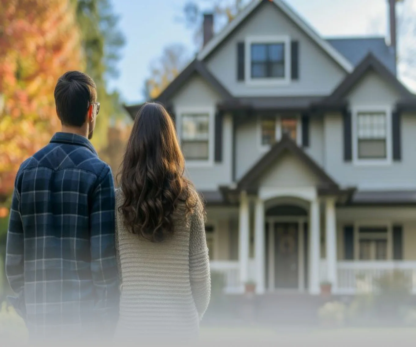 A man and a woman with their backs to the camera looking at a home. Possibly potential homebuyers.