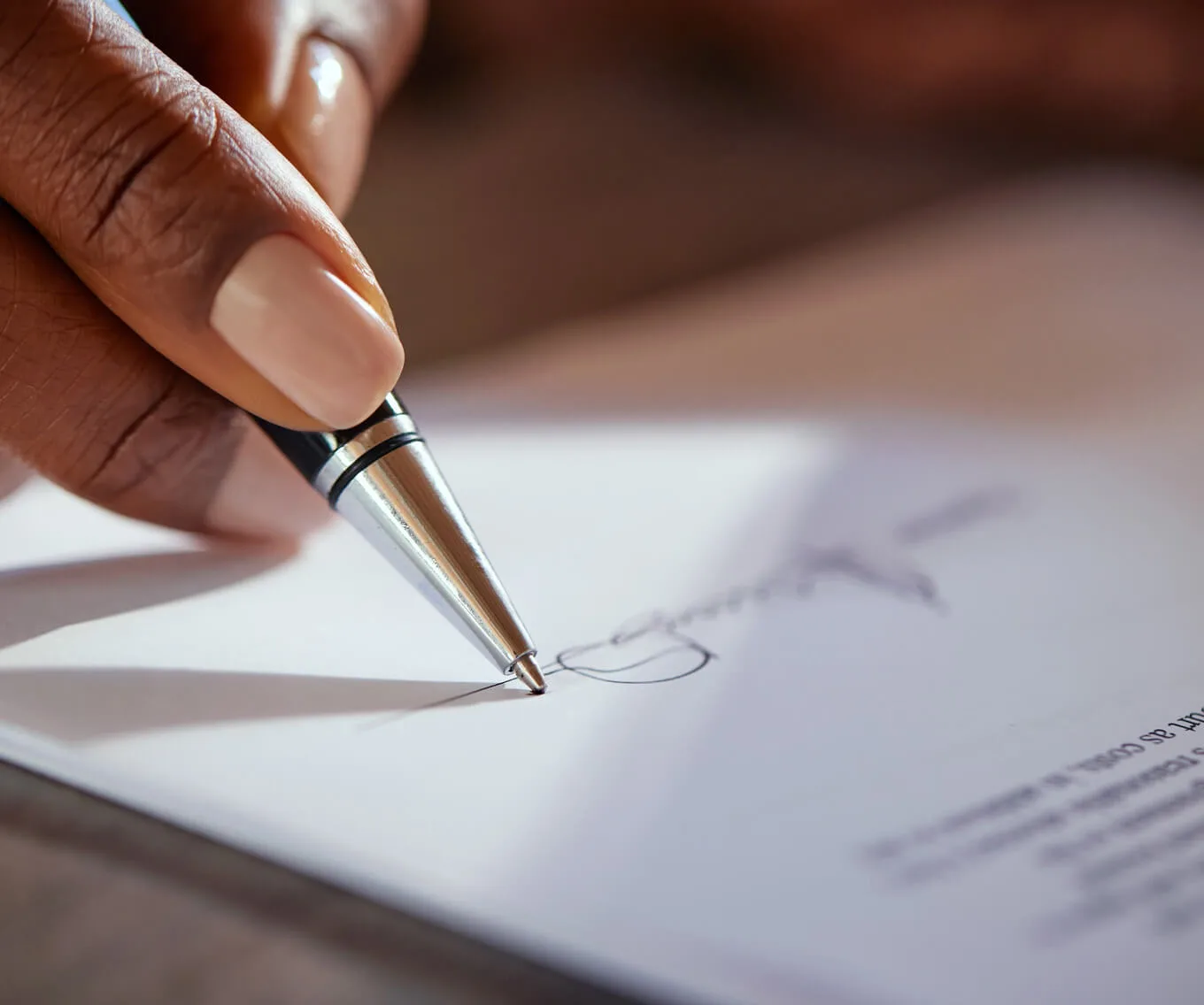 Person signing a real estate document, illustrating the grantor vs grantee property transfer process.
