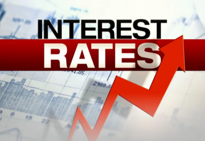 An arrow pointing up with the words "Interest Rates" in the background of the image along with graphs.