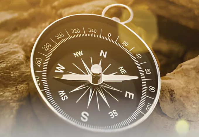 A compass sitting on rocks.