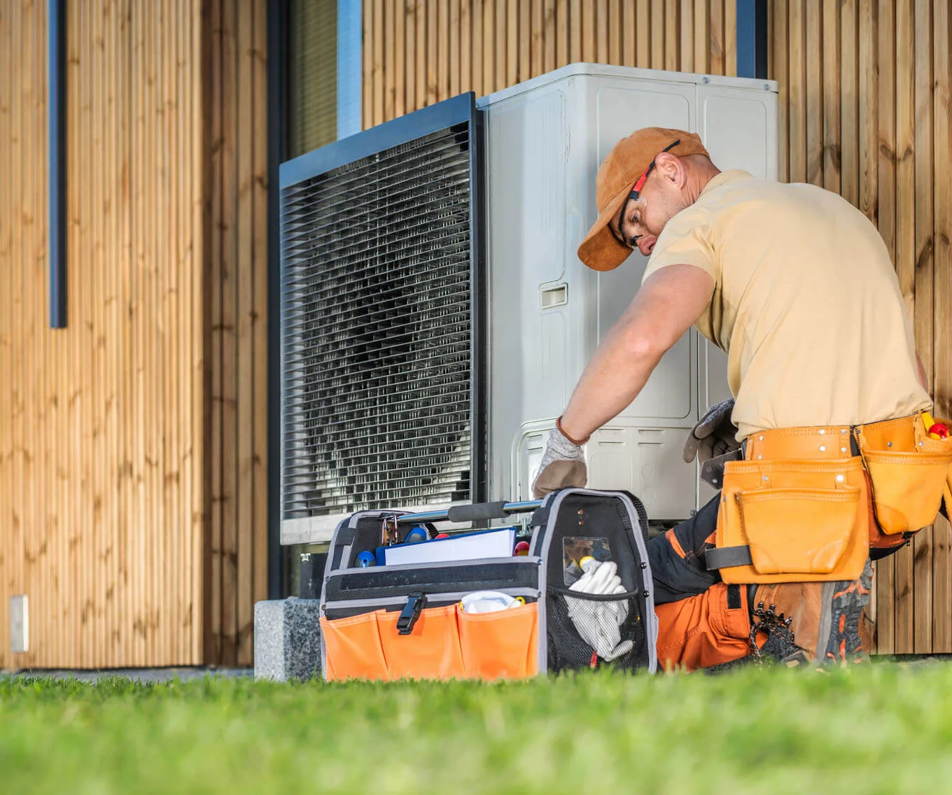 HVAC technician repairing an outdoor air conditioning unit at a home covered by a home warranty.