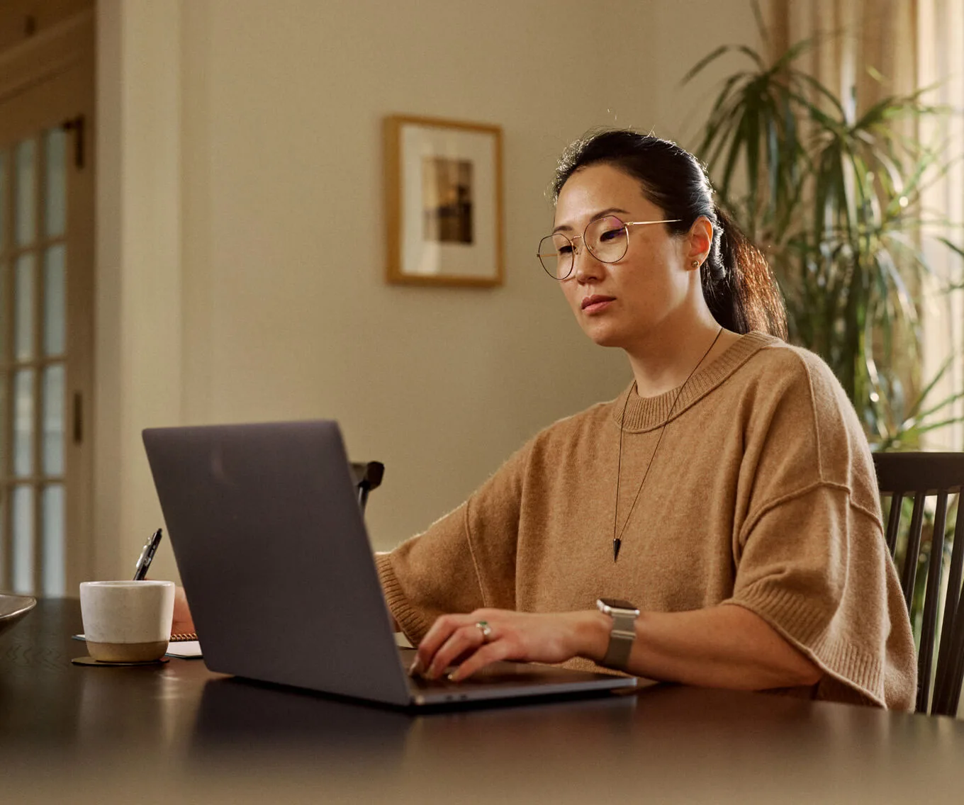 Woman sitting at a laptop reviewing finances and loan information related to refinancing a home equity loan.