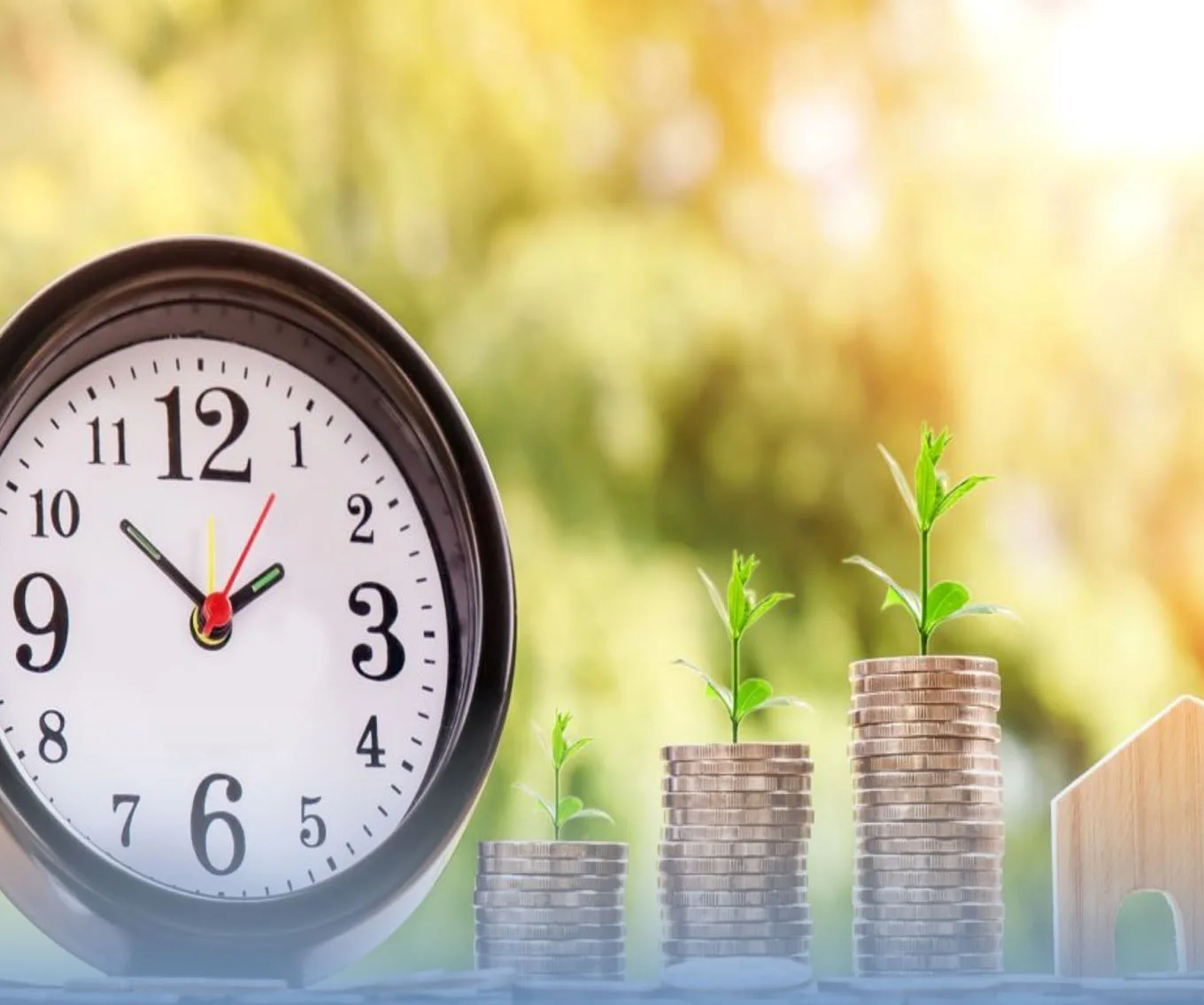 A small clock next to three stacks of coins with a plant sprouting out of each.