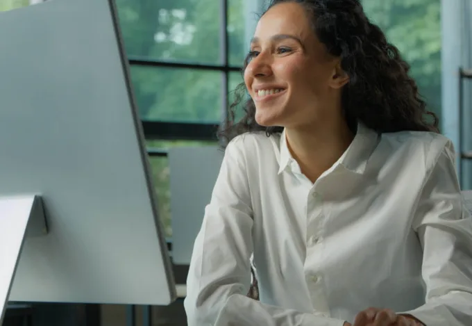 Woman using a computer to research who owns a property online.