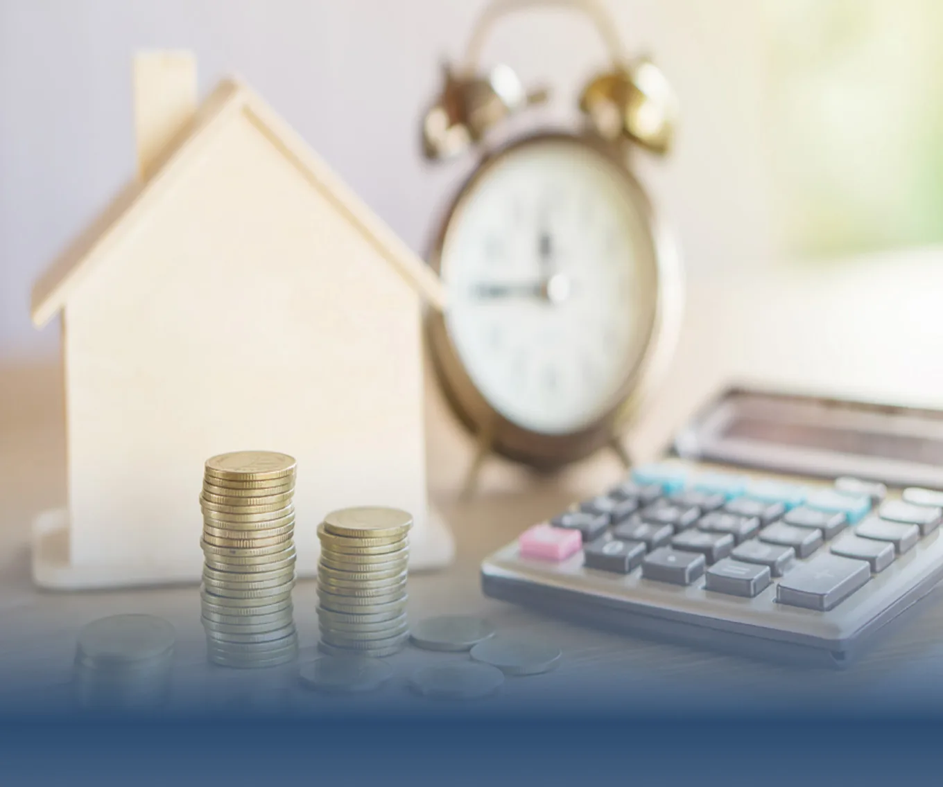 Stacked coins, a calculator, an alarm clock, and a wooden house model representing home financing and budgeting