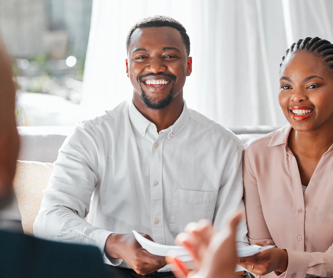 Couple reviewing mortgage documents with a loan officer while preparing to use gift funds for a home purchase.