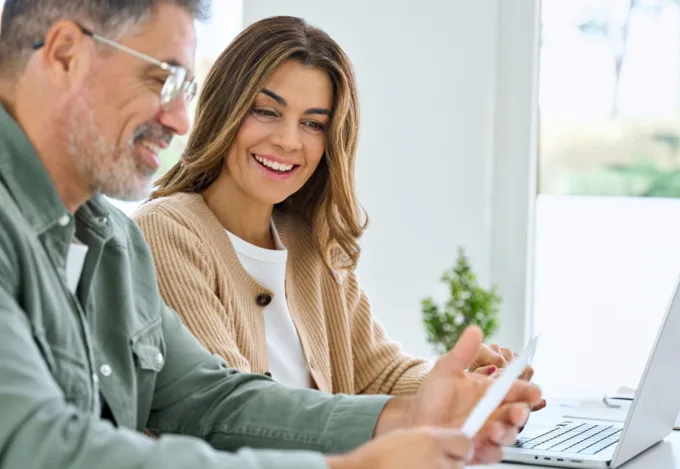 Homeowners reviewing second mortgage and home equity loan options together on a laptop.