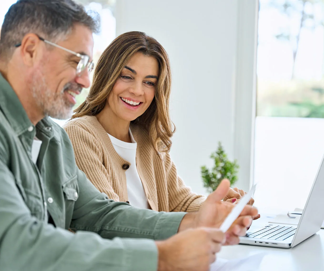 Homeowners reviewing second mortgage and home equity loan options together on a laptop.